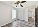 A charming bedroom with gray vinyl flooring, a lighted ceiling fan, and a double closet at 915 Brittany Park Blvd, Tarpon Springs, FL 34689