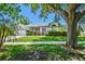 Landscaped front yard featuring mature trees and well-maintained lawn at 915 Brittany Park Blvd, Tarpon Springs, FL 34689