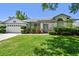 Charming home with a well-manicured front lawn and mature shrubbery at 915 Brittany Park Blvd, Tarpon Springs, FL 34689