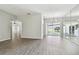 Bright living room featuring hardwood floors, sliding glass doors, and mirrored wall at 915 Brittany Park Blvd, Tarpon Springs, FL 34689