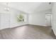 Open-concept living room with wood floors, white trim, and large window at 915 Brittany Park Blvd, Tarpon Springs, FL 34689