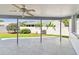 Covered patio provides shade and view of manicured lawn and white vinyl fencing at 915 Brittany Park Blvd, Tarpon Springs, FL 34689