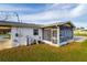 Rear view of home showing screen patio, white exterior, and propane tanks at 9170 Dupont Ave, Spring Hill, FL 34608