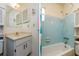 Bright bathroom featuring a vanity with storage and a bathtub with blue tile surround at 9170 Dupont Ave, Spring Hill, FL 34608