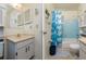 Cozy bathroom with a vanity, toilet, bathtub with blue tile surround, and shower with curtain at 9170 Dupont Ave, Spring Hill, FL 34608
