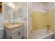 Bright bathroom featuring a vanity, toilet, and shower/tub with yellow tile surround and butterfly curtain at 9170 Dupont Ave, Spring Hill, FL 34608