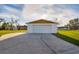 View of the home's garage with a long driveway and lush lawn at 9170 Dupont Ave, Spring Hill, FL 34608