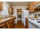 A kitchen with wood cabinets, white appliances, and view to the utility room at 9170 Dupont Ave, Spring Hill, FL 34608