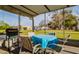 Screened back patio with outdoor seating and a grill overlooking the backyard at 9170 Dupont Ave, Spring Hill, FL 34608