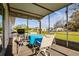View of the home's screened in porch, complete with table, chairs and grill at 9170 Dupont Ave, Spring Hill, FL 34608