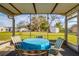 Screened in porch with a table and four chairs overlooking the yard at 9170 Dupont Ave, Spring Hill, FL 34608