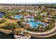 Aerial view of the community featuring pools, a covered pavilion, walking paths and lush landscaping around a pond at 9505 Lemon Drop Loop, Ruskin, FL 33573