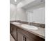 Bathroom featuring double sinks with granite countertops, a large mirror, and lots of lights at 9505 Lemon Drop Loop, Ruskin, FL 33573