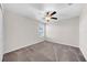 This bedroom features a ceiling fan, neutral walls, plush carpeting, and a window offering natural light at 9505 Lemon Drop Loop, Ruskin, FL 33573