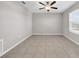 Neutral bedroom boasts tile floors, a ceiling fan, a window with blinds, and ample natural light at 9505 Lemon Drop Loop, Ruskin, FL 33573