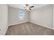 This bedroom features a ceiling fan, neutral walls, plush carpeting, and a window offering natural light at 9505 Lemon Drop Loop, Ruskin, FL 33573