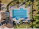 Aerial view of lap pool with neatly arranged lounge chairs, umbrellas, and tropical landscaping surrounding the space at 9505 Lemon Drop Loop, Ruskin, FL 33573