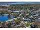 Overhead view of the property near a serene lake, surrounded by lush trees and neighborhood streets at 9862 48Th N Ave, St Petersburg, FL 33708