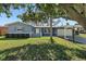 Charming single-story home featuring a manicured lawn, lush landscaping, and a carport for convenient parking at 9862 48Th N Ave, St Petersburg, FL 33708