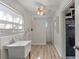 Bright laundry room with sink, window, and wood-look flooring at 9862 48Th N Ave, St Petersburg, FL 33708
