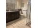 Bathroom featuring a granite countertop, dark brown cabinets, and glass shower at 11648 Palmetto Pine St, Riverview, FL 33569