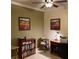 Office space featuring ceiling fan, desk, colorful art and built-in shelving at 11648 Palmetto Pine St, Riverview, FL 33569