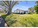 A view of the home's exterior showing the lush lawn and mature trees in the neighborhood at 1022 Mctavish Way, Palm Harbor, FL 34684