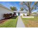 Close-up of a home's entrance with a walkway, blue front door, and tidy landscaping at 1022 Mctavish Way, Palm Harbor, FL 34684