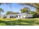 Well-kept home exterior with a clean white facade, attached garage, and a spacious green lawn at 1022 Mctavish Way, Palm Harbor, FL 34684