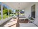 Relaxing screened-in porch with comfortable lounge furniture and a dining set, offering serene outdoor living at 1022 Mctavish Way, Palm Harbor, FL 34684
