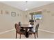 Dining room with a round wooden table, four chairs, and a window with natural light at 11745 Brighton Knoll Loop, Riverview, FL 33579