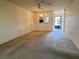 Spacious living room featuring neutral carpet, fan and partial view to the kitchen at 1374 Mission Hills Blvd, Clearwater, FL 33759