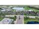 Expansive aerial showcasing community clubhouse, parking, landscaping, and water feature at 14191 Heritage Landing Boulevard # 1234, Punta Gorda, FL 33955