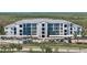 Wide aerial view of the condo building, showcasing its parking and the greenery surrounding the property at 14191 Heritage Landing Boulevard # 1234, Punta Gorda, FL 33955