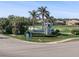 A welcoming community entrance sign featuring palm trees, lush landscaping and professional signage at 14191 Heritage Landing Boulevard # 1234, Punta Gorda, FL 33955