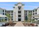 Stylish four-story condo building entrance featuring well-manicured landscaping and convenient accessibility at 14191 Heritage Landing Boulevard # 1234, Punta Gorda, FL 33955