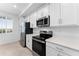 Close-up of a modern kitchen with white cabinets, stainless steel appliances, and quartz countertops at 14191 Heritage Landing Boulevard # 1234, Punta Gorda, FL 33955