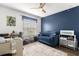 Inviting bedroom featuring blue accent wall, comfortable seating, and ample natural light at 18130 Arbor Crest Dr, Hudson, FL 34667