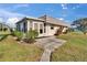 Lovely home exterior featuring a well-manicured lawn, lush landscaping and a cozy enclosed porch at 206 Andover N Pl # 96, Sun City Center, FL 33573