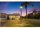 Charming home exterior featuring a well-manicured lawn, mature trees, and a cozy enclosed porch under a colorful sky at 206 Andover N Pl # 96, Sun City Center, FL 33573