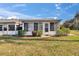 Lovely home exterior featuring a well-manicured lawn, lush landscaping and a cozy enclosed porch at 206 Andover N Pl # 96, Sun City Center, FL 33573