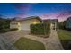 Charming single-story home featuring a two-car garage, screened-in porch, and lush landscaping at 221 Sela Cove Cir, Apollo Beach, FL 33572