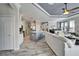 Open-concept living room and kitchen with light gray tones, wood-look tile floors, and gray island at 221 Sela Cove Cir, Apollo Beach, FL 33572