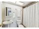 Bathroom with pedestal sink, toilet, and shower with curtain at 2515 S Ysabella Ave, Tampa, FL 33629