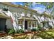 A classic townhouse with a covered entry, lush plantings and a nearby walkway showing a connection to the neighborhood at 2515 S Ysabella Ave, Tampa, FL 33629