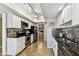 Galley kitchen with stainless steel appliances, white cabinets, and a tile backsplash at 2515 S Ysabella Ave, Tampa, FL 33629
