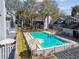 Community pool surrounded by a black fence with chairs and tables for residents in a tranquil environment at 2515 S Ysabella Ave, Tampa, FL 33629