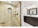 Bathroom featuring walk-in shower with mosaic tile floor, stone walls, and a built-in niche at 2515 S Ysabella Ave, Tampa, FL 33629