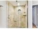 Walk-in shower featuring a glass door, stone walls, and elegant shower head at 2515 S Ysabella Ave, Tampa, FL 33629