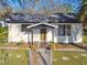 Charming bungalow features a fenced yard, porch, and shady mature landscaping at 2801 N 75Th St, Tampa, FL 33619